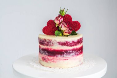 Sevgililer günü için gül ve kalpleri ile dekore edilmiş küçük bir kırmızı ve beyaz pasta