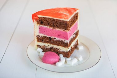 Çeşitli çok renkli dilim kek Beyaz ahşap bir masa üzerinde bir plaka üzerinde