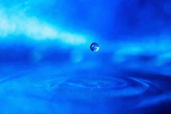 Una Gota Agua Sobre Fondo Azul Con Luz Humeante —  Fotos de Stock