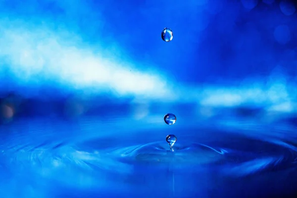 Droppe Vatten Blå Bakgrund Rökiga Ljus — Stockfoto