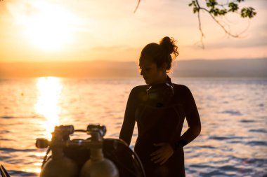 Dalış Eğitmeni Dalış Ustası Islak Elbise Giyiyor Gün batımında İkiz Tankın yanında duruyor