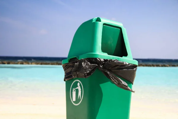 Green Plastic Bin on Clean Sandy Tropical Beach after Recycling Waste