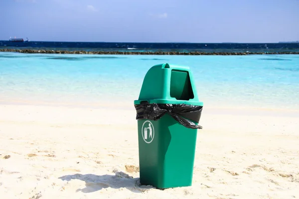 Green Plastic Bin on Clean Sandy Tropical Beach after Recycling Waste