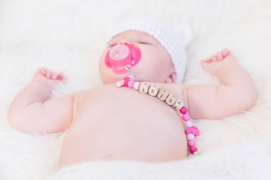 Baby Girl Named Leila Sleeping and Wearing a Wooden Pacifier Chain clipart