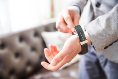 Takım Elbiseli Adam Saatini Bileğine Ayarlıyor