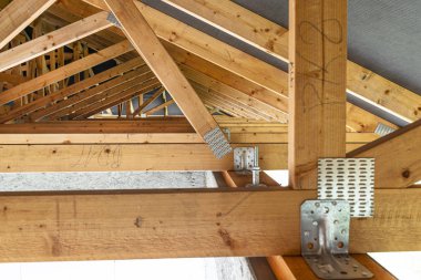 Çatı kirişleri yapım aşamasındaki müstakil bir evin zarı, içeriden görüş, görünür çatı unsurları ve kiriş plakaları ile kaplıdır..