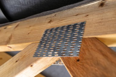 Çatı kirişleri yapım aşamasındaki müstakil bir evin zarı, içeriden görüş, görünür çatı unsurları ve kiriş plakaları ile kaplıdır..