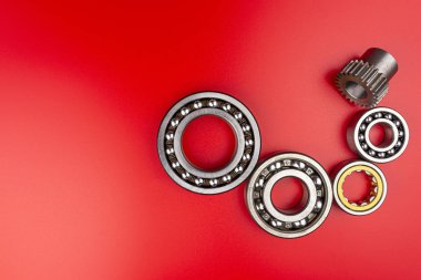 Kırmızı zemin üzerinde duran bilye, kenarlarında da fotokopi alanı. Yukarıdan düz görünüm.