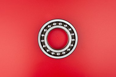 Tek top yatağı yakın, kırmızı arkaplanda izole edilmiş, yanlarda kopyalama alanı var..