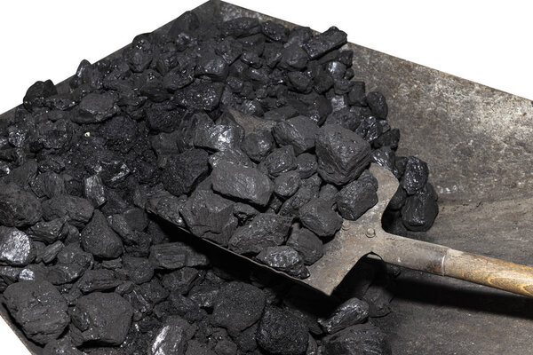 Wheelbarrow loaded with coal on which the shovel lies, isolated on a white background with a clipping path.