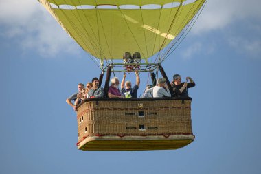 Wershofen, Almanya 3 Eylül 2017. Yeşil bir sıcak hava balonu fırlatıyorlar, insanlar gondolda duruyorlar. Balon havada süzülüyor.