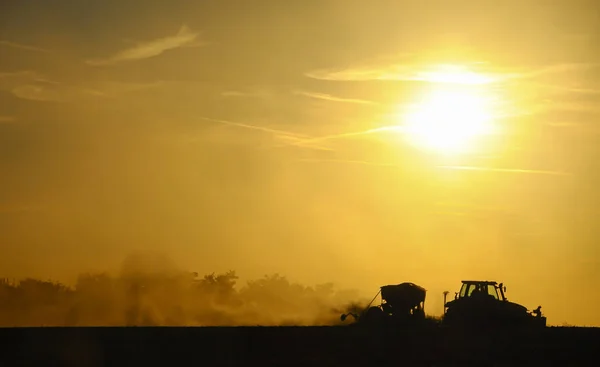 Silueta Tractor Sembrando Semillas Campo Una Nube Polvo Sobre Fondo — Foto de Stock