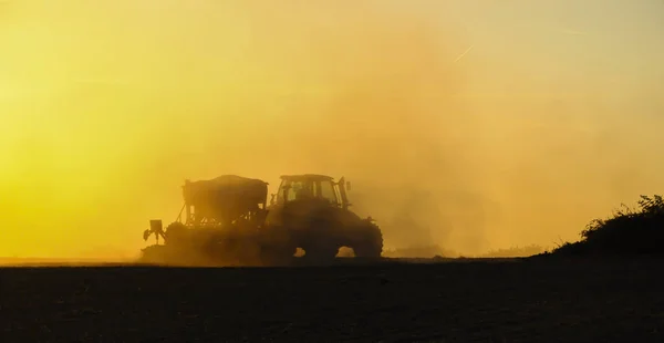 Силуэт Трактора Сеющего Семена Поле Облаке Пыли Фоне Заходящего Солнца — стоковое фото