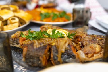 Polonya 'da bir Noel masasında limonlu ve maydanozlu kızarmış balık filetosu..