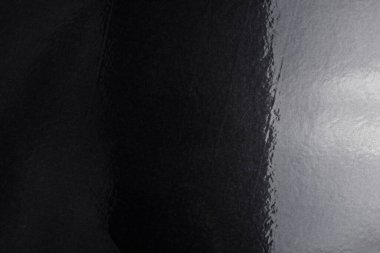 Alüminyum folyoyla kaplanmış gerçek, parlak siyah kağıttan yapılmış siyah zemin, sağdan gelen yumuşak bir ışıkla aydınlatılmış..