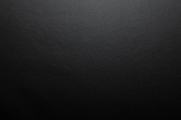 Yukardan gelen yumuşak bir ışıkla aydınlatılan fibröz yapıya sahip gerçek siyah kağıttan yapılmış siyah arkaplan..