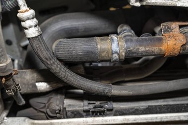 Lastik borular ve hortumlar arabanın radyatöründen motora, motorun alt görüntüsüne gidiyor..