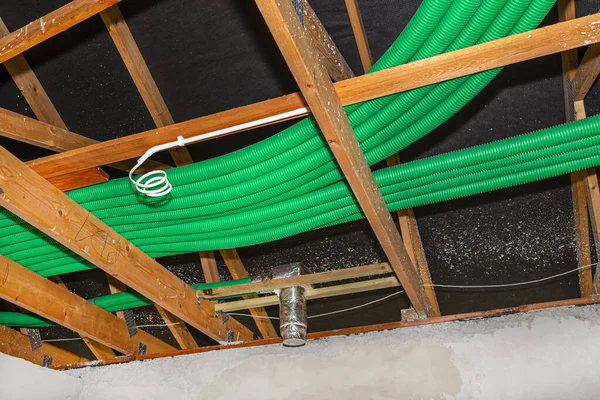 家庭のエネルギー回収換気 屋根のトラス上に広がる空気輸送のための緑の柔軟なパイプの目に見えるシステム — ストック写真