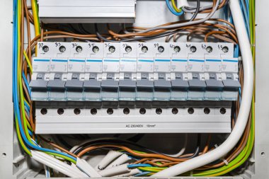 Kapalı konumda tek fazlı sigortalar, ev sigorta kutusuna yerleştirilmiş, görünür elektrik kabloları..