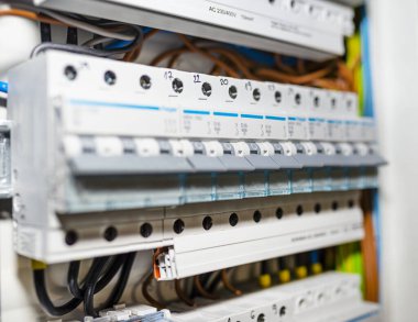 Tek fazlı sigortalar ve üç aşamalı sigortalar, ev sigorta kutusuna yerleştirilmiş, görülebilir elektrik kabloları..