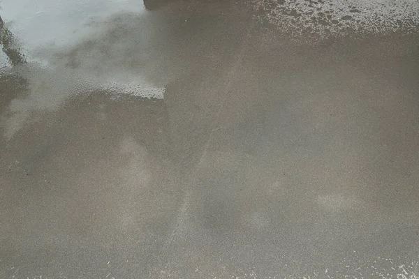 Watering a newly poured floor screed at home to prevent it from cracking.