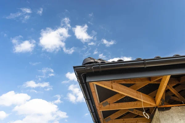 青い空に対するアントラサイトの新しいセラミックタイルで覆われた一戸建ての屋根 目に見える信頼 — ストック写真