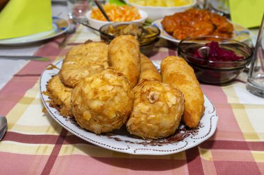 Süslü bir masada duran içi doldurulmuş Polonya kroketleri görünür mantarlar ve pancarlar..