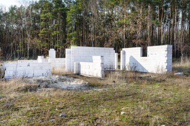 Terk edilmiş ev inşaatı, hücresel betondan yapılmış yük taşıyan duvarlar, görünür destek çubukları..