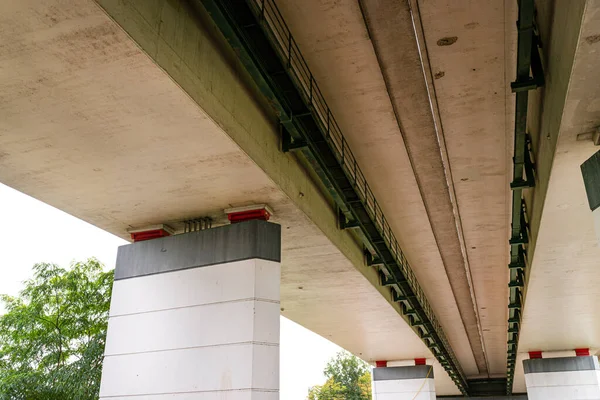 下から見えるコンクリート製の高速道路橋 見えるコンクリート製の柱 — ストック写真