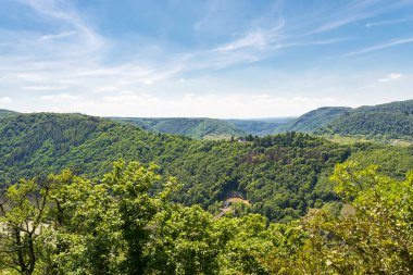 Bahar mevsiminde Batı Almanya 'da güzel, olgunlaşan üzüm bağları tepelerde ve bulutlu mavi gökyüzünde büyüyen görünür ormanlar..