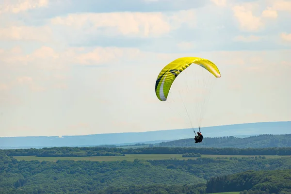 Man Som Flyger Grön Paraglider Över Skog Molnig Dag — Stockfoto