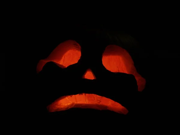Gruselige Halloween-Kürbisse isoliert auf schwarzem Hintergrund. Glühende Gesichter tricksen oder behandeln — Stockfoto