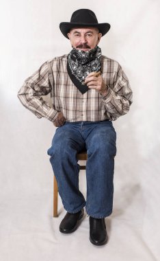 Bıyıklı siyah şapkalı bir puro sigara bir kovboy