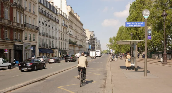 According to the Quai Voltaire moving pedestrians, cyclists and Royalty Free Stock Images