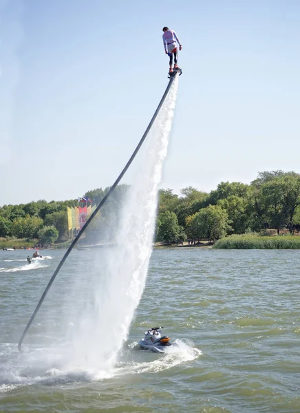 The athlete flies with a water jet from the side of a water mot — Stock Photo, Image