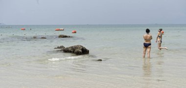 İnsanlar güneşlenmek ve yüz. Kız denizde bir fotoğraf için poz veriyor