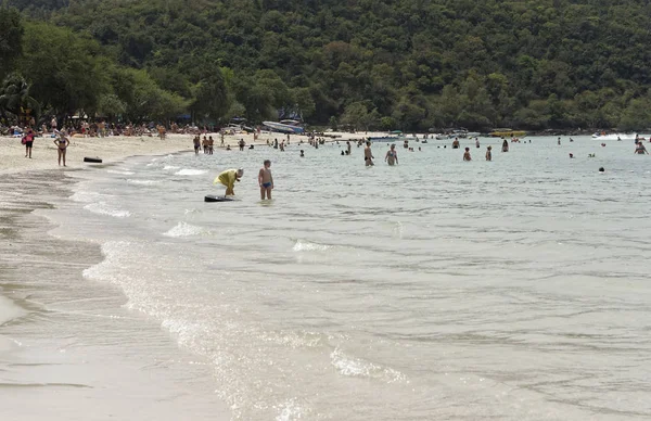 People sunbathe and swim.Some vacationers stroll along the shore — Stock Photo, Image