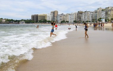 Rio de Janeiro, Brasil- 26 Şubat 2020: Tatilciler Copacabana sahilinde okyanusta yüzerler