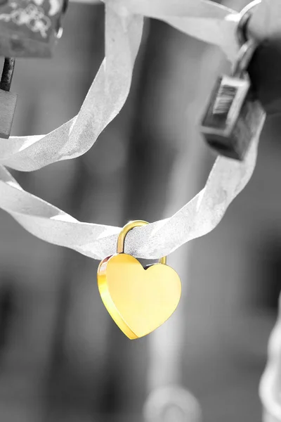 A metallic heart shaped love padlock isolated on black and white background. Clipping path available