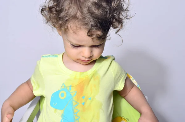 Beautiful curly toddler looking surprised, boy being upset because he got dirty while eating — Stock Photo, Image