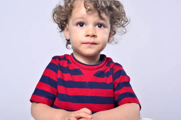 Hermoso niño rizado mirando hacia adelante, ojos grandes chico asustado —  Fotos de Stock