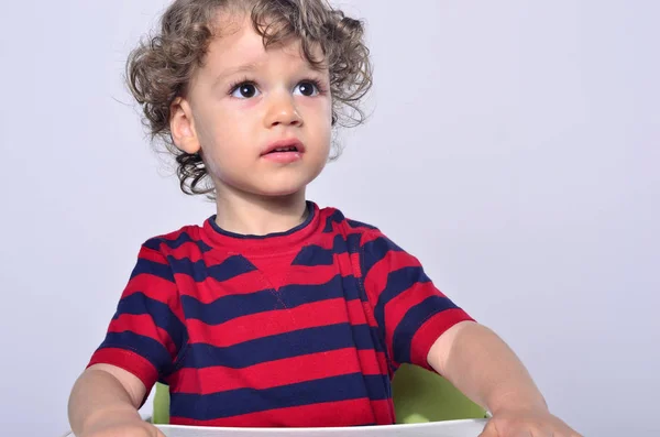 Beautiful curly toddler looking up, big eyes scared boy — Stock Photo, Image