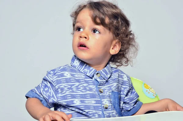 Hermoso niño rizado mirando asustado, ojos grandes chico buscando a sus padres — Foto de Stock