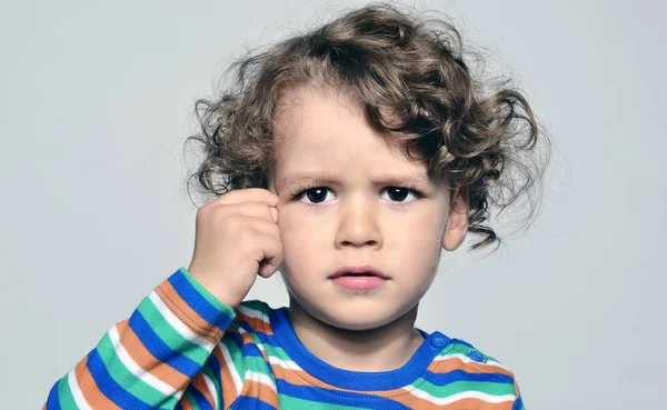 Hermoso niño rizado mirando hacia adelante y pensando, ojos grandes chico molesto — Foto de Stock