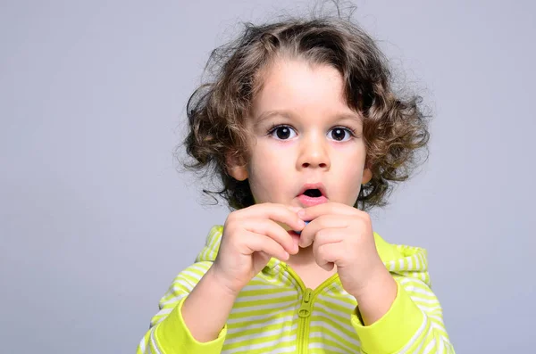 Gyönyörű fiú eszik cukorka. Kisgyermek birtoklás móka-val egy kicsi darab-ból cukor. Gyerek, evés és beszél az azonos időben — Stock Fotó
