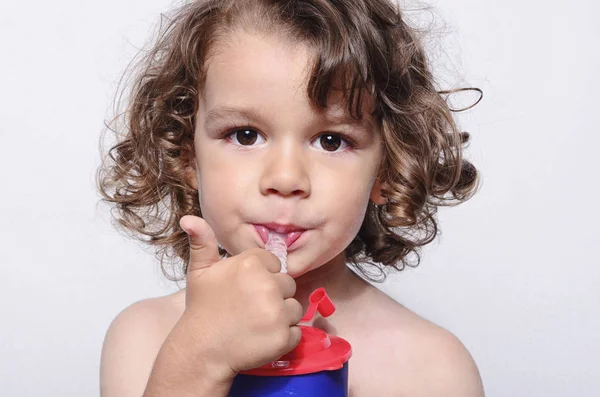 Mooie jongen vers drinkwater. Schattig peuter proeverij van zoete sap met een rietje — Stockfoto