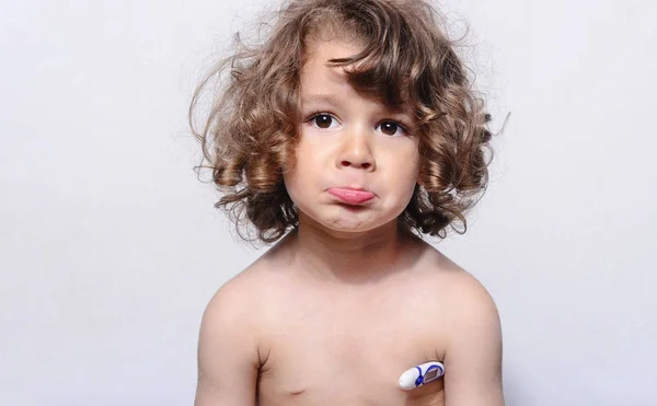 Toddler sjuka, försöker få hans temperatur med en termometer. Sorgliga sjuk pojke, med en influensa. Vackra pojke fick en kall och han får en behandling. — Stockfoto