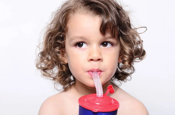 Mooie jongen vers drinkwater. Schattig peuter proeverij van zoete sap met een rietje — Stockfoto