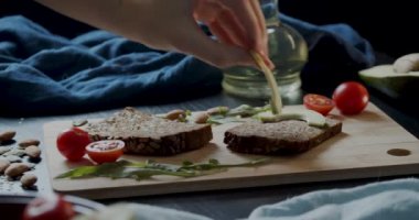 Siyah ekmeğin üzerine avokado ve kiraz dilimleri koyun.