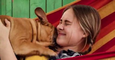 At kuyruklu genç kız hamakta köpekle oynuyor, yakın plan.